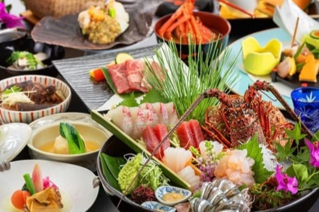 パームツリーと青い空が広がるリゾートバイト先ホテルのテラス。白いテーブルと椅子が並び、その奥には海が見える。