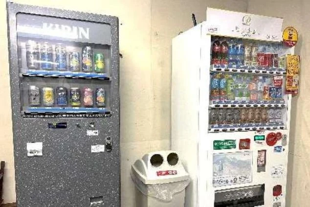 リゾートバイト寮の共用部に設置された自動販売機。飲料やお酒が購入でき、寮生活の利便性を高める設備の画像。