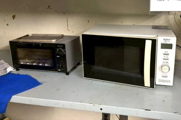 リゾートバイト寮の共用キッチン設備の写真。電子レンジとオーブントースターが設置されており、自炊や温め直しが可能。