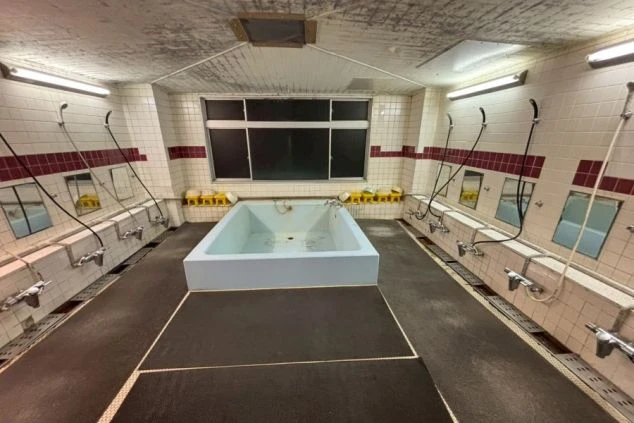 リゾートバイト寮の共同浴場(お風呂)の写真。広い湯船と多数のシャワーブースがあり、仕事の疲れを癒せる環境。