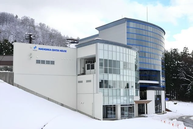 雪山を背景に立つ、モダンなスキーセンター「NAGASAKA CENTER HOUSE」。野沢温泉スキー場の拠点となる施設。