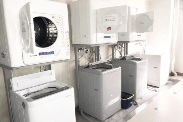 リゾートバイトの相部屋寮の共用洗濯機・乾燥機の画像。