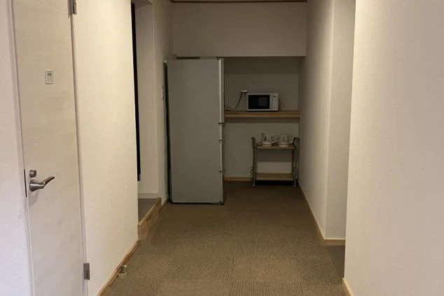 リゾートバイトの寮の部屋の中を撮影した画像。部屋の入り口付近には冷蔵庫と電子レンジが置かれており、生活に役立つ家電が備え付けられていることがわかる。リゾートバイトの寮の共用スペースの画像。