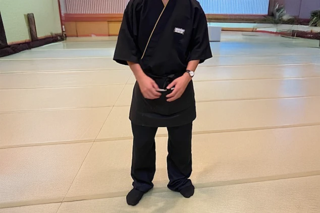 黒い作務衣風の制服を着用し、和の雰囲気を演出。旅館接客やホールサービスの仕事をアピール。
