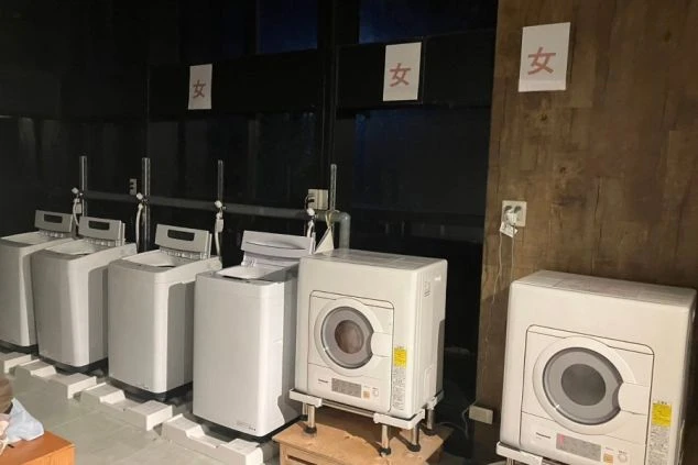 寮の洗濯室。洗濯機、乾燥機が並ぶ。