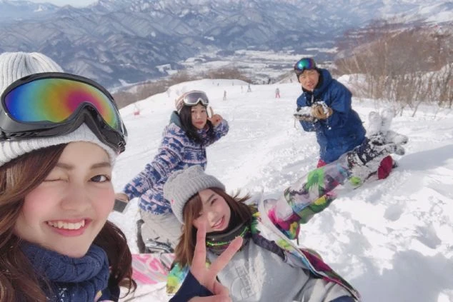 雪山で楽しそうに自撮りをする若者たち。ウィンタースポーツを楽しむリゾートバイトの仲間。