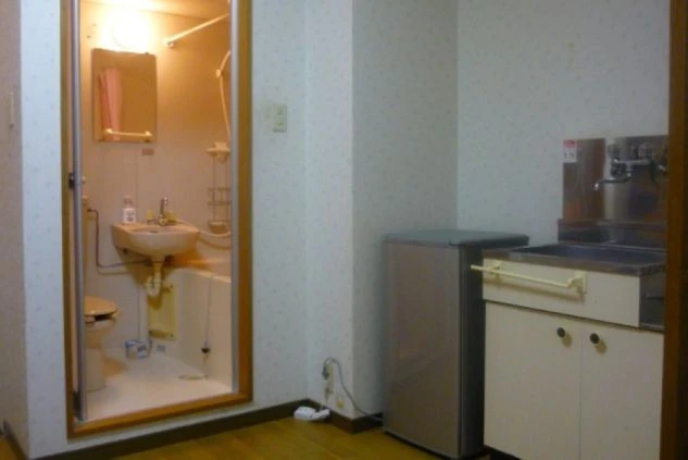 リゾートバイトの相部屋寮のキッチンとユニットバスの画像。