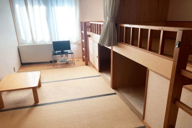 リゾートバイトの相部屋寮の部屋の画像。畳の寝室でベッドの下には広い収納がある。