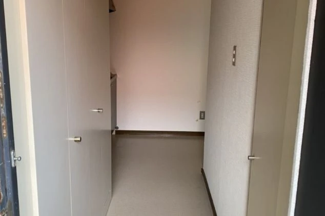 リゾートバイトの個室寮の玄関から続く廊下。清潔感があり、奥にはミニキッチンが見える、入居後すぐに生活を始められる寮画像。