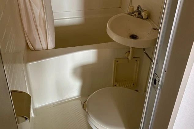 リゾートバイトの個室寮にあるユニットバス。浴槽、洗面台、トイレが一体となった、プライベートな空間で利用できる清潔な寮画像。