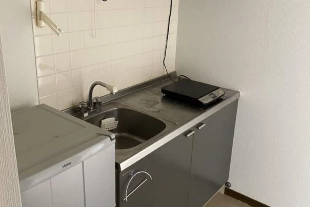 リゾートバイトの個室寮にあるミニキッチン。シンクとIHクッキングヒーター、冷蔵庫が備え付けられており、自炊ができる便利な設備の寮画像。