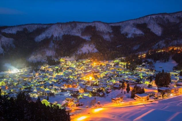 野沢温泉の夜景の画像。雪化粧した町並みがライトアップされ、幻想的な雰囲気を醸し出す。リゾートバイトの勤務後に楽しめる美しい夜景。