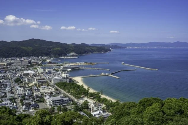 瀬戸内海に面した高台に建つリゾートホテルの全景。遠くには瀬戸大橋が見え、美しいオーシャンビューが魅力の、リゾートバイトの勤務地をイメージさせる画像。