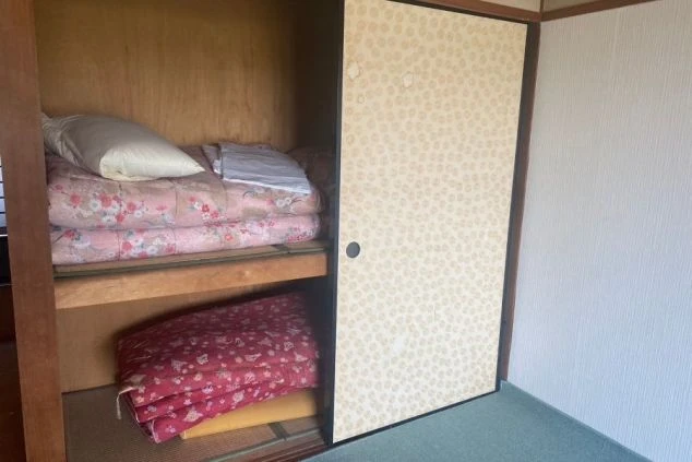 リゾートバイトの寮の和室にある押し入れ。布団一式が用意されており、収納スペースも確保されています。