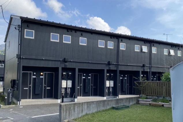 リゾートバイトの寮の晴れた日の外観画像。黒のお洒落で新しいアパート。