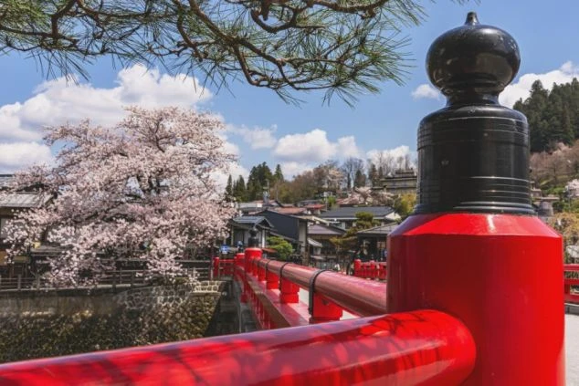 夕暮れ時の古い街並み。木造建築の家々が提灯の明かりで照らされ、幻想的な雰囲気を醸し出す。