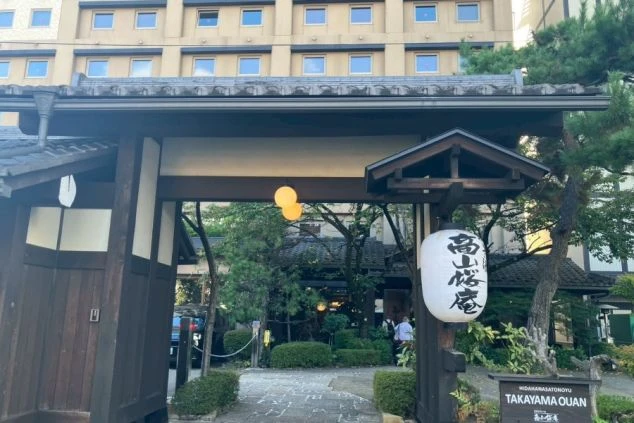  格式高い門構えの奥にそびえ立つ、高層の旅館。伝統とモダンが融合した外観が印象的。