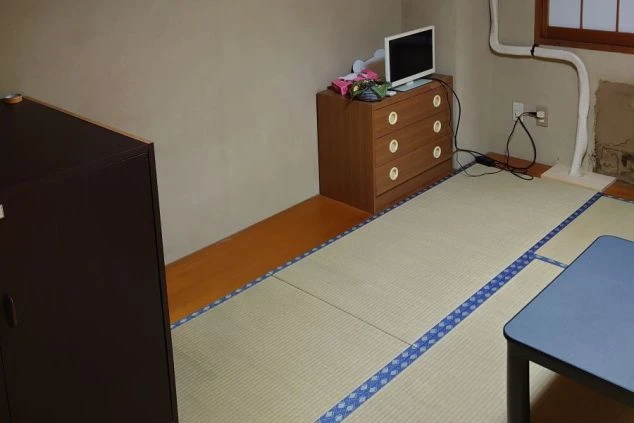 リゾートバイトの個室寮の部屋の画像。小さなTVと収納、テーブルが見える。