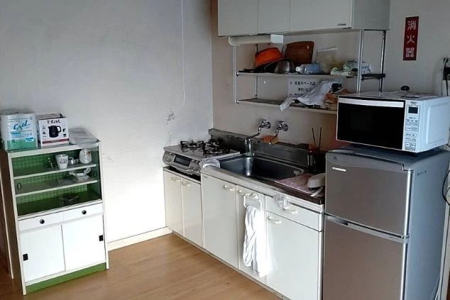 リゾートバイトの個室寮の共用キッチンの画像。電子レンジ・冷蔵庫・コンロが見える。