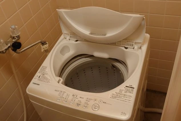 リゾートバイトの個室寮の共用洗濯機の画像。