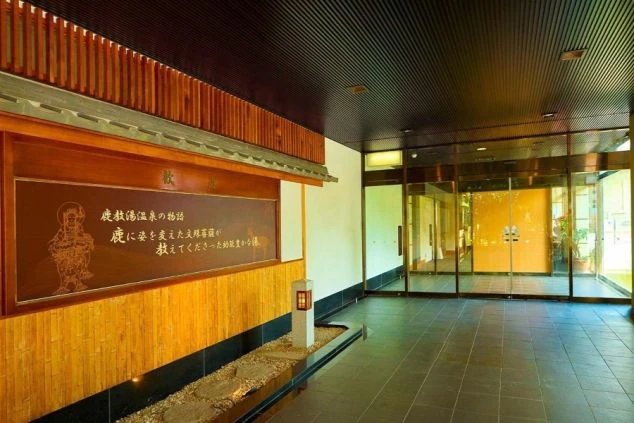 旅館の玄関の画像。木製の看板には文字が書かれ、落ち着いた雰囲気のロビーが広がる。リゾートバイトの職場となる施設の入り口。