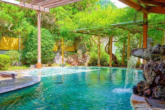 緑豊かな露天風呂の画像。湯舟には水が注がれ、周囲は木々に囲まれ自然を満喫できる。