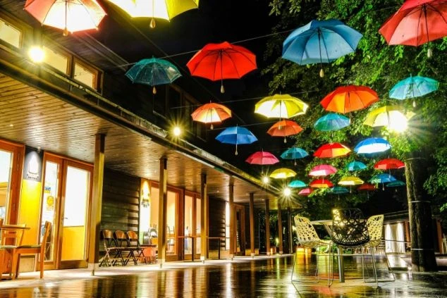 夜空に浮かぶカラフルなアンブレラ。ライトアップされたテラス席が幻想的な空間を作り出す。