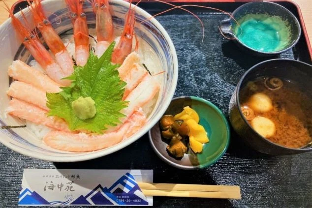 丼に盛り付けられたエビとカニの海鮮丼、味噌汁、小鉢がセットになった食事。リゾートバイトのまかないが充実していることや、海鮮料理を提供する飲食店での仕事に興味がある方に魅力的な画像。