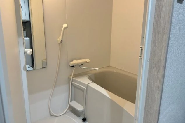 リゾートバイトの個室寮にあるバスルーム。浴槽とシャワーが一体になった、プライベートで清潔な設備の画像。