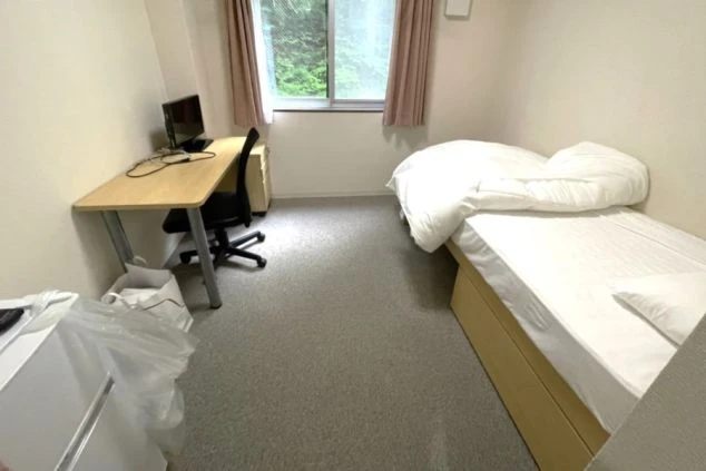 リゾートバイトの個室寮の部屋の画像。ベッド、机、チェア、冷蔵庫がありとても綺麗な内装。