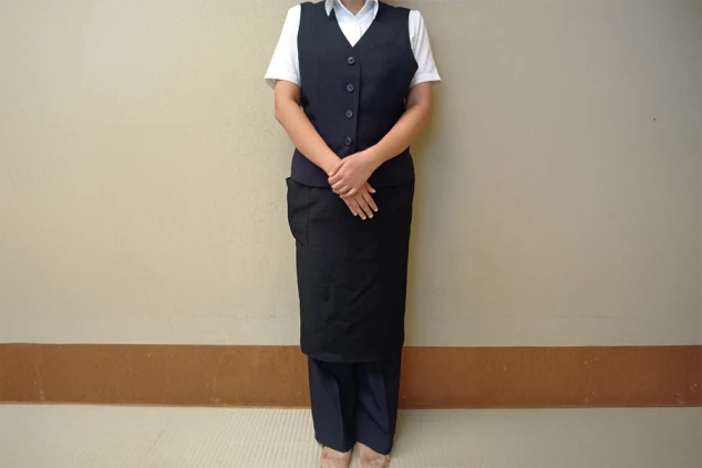 リゾートバイトの仕事風景を表現するイメージ画像。サービス・ホールの仕事で着用する、白いシャツに黒いベストとスカート。