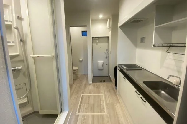 寮の玄関から続く廊下。右手にキッチン、奥にトイレが見え、生活しやすい動線。