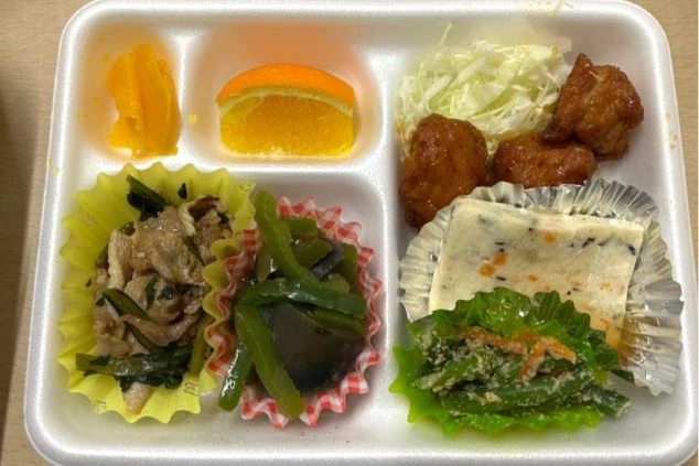 白の発泡スチロール容器に詰められた彩り豊かなまかない弁当。