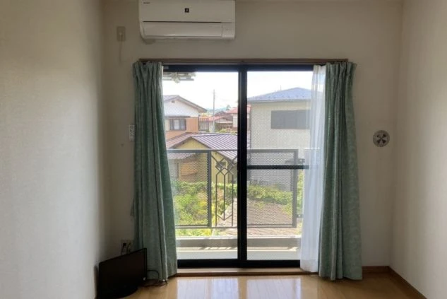 河口湖のリゾートバイトの寮の窓の画像。ベランダがあり、カーテンが開いている。