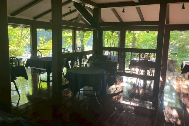 森の中にあるレストランのダイニングの画像。大きな窓から光が差し込み、開放的な空間が広がっている。リゾートバイトの仕事内容を表す、レストランのダイニングの画像。