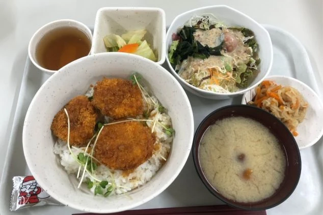 リゾートバイトで提供される賄いの画像。メイン、副菜、ご飯、味噌汁がセットになった食事メニュー。