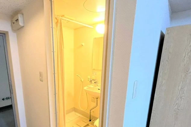 リゾートバイトの個室寮の部屋内にあるユニットバスの画像。左には玄関、右には収納が見える。