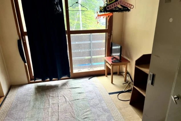 リゾートバイトの相部屋寮の部屋の画像。畳の上にTVが乗った小さなテーブルがある。。