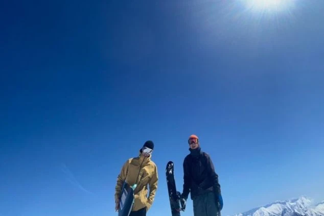 リゾートバイトで出会った仲間と、ゲレンデの山頂へ。青空の下、白銀の世界を二人占めする、最高の瞬間です。