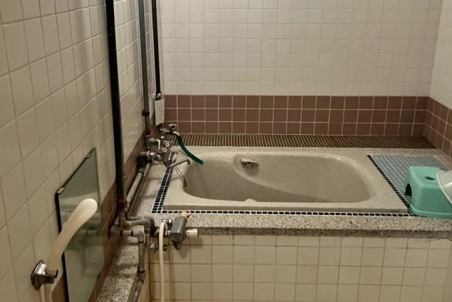 寮の浴室の画像。タイル張りの浴槽とシャワーが備え付けられており、清潔感がある。リゾートバイト中の入浴設備。