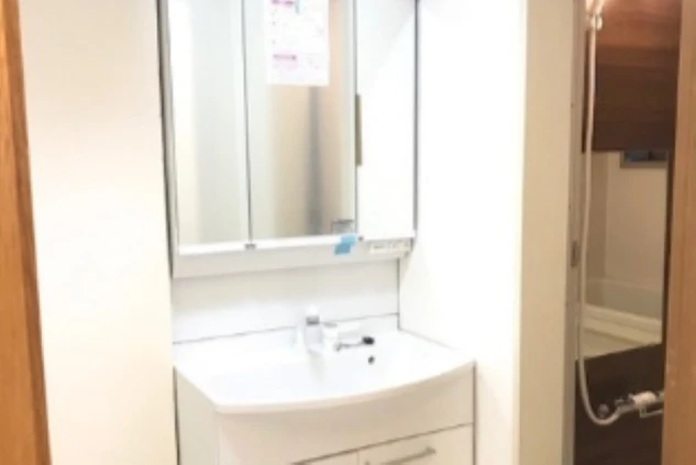 リゾートバイトの寮に完備された、白を基調とした清潔な独立洗面台。大きな鏡と収納が付いている。