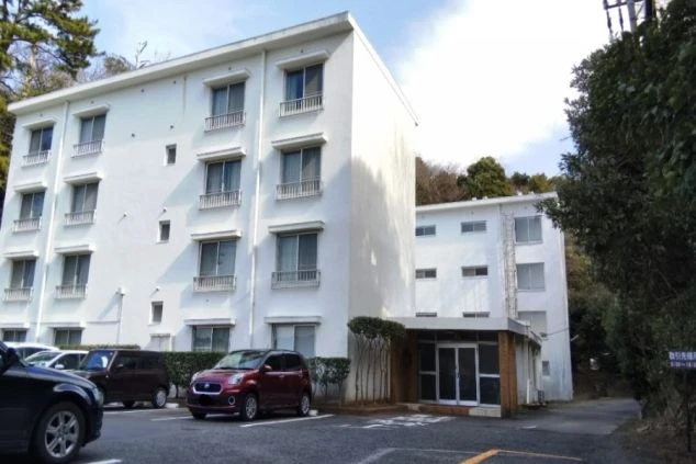 三重県鳥羽でのリゾートバイトの寮外観の画像。白い壁の4階建ての建物。