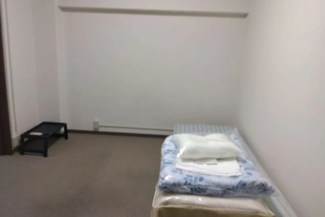 リゾートバイトの寮の個室。カーペット敷きのシンプルな部屋に、ベッドが用意されています。
