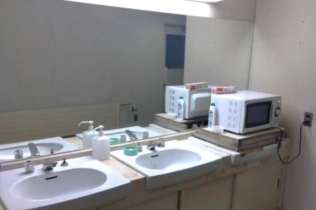 リゾートバイトの寮の洗面所。複数のシンクと大きな鏡があり、電子レンジも設置されているため、身支度や軽食の温めに便利です。