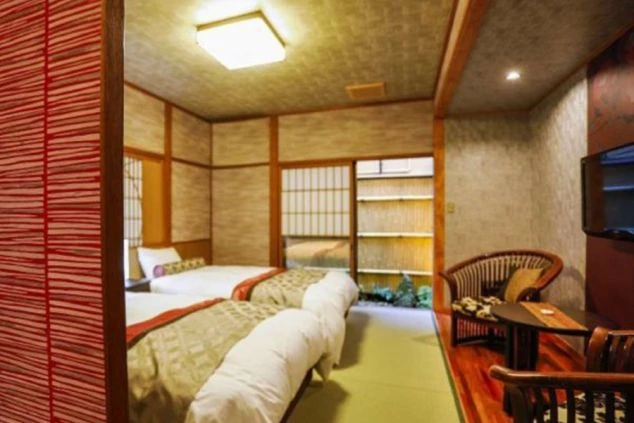 和風モダンの内装が特徴的な旅館の客室。ベッドが2台置かれ、和の雰囲気を感じながらも快適に過ごせる部屋で、リゾートバイトで働く場所のイメージが伝わる画像。