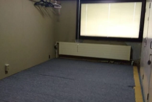 リゾートバイトの男性寮の相部屋。広めの部屋に窓があり、ハンガーラックとロッカーも備え付けられています。