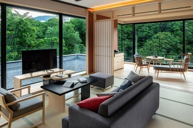 山々の絶景が見えるホテルの和モダンな客室。ソファ、テーブル、テレビが備え付けられたイメージ画像。リゾートバイトの職場の様子。