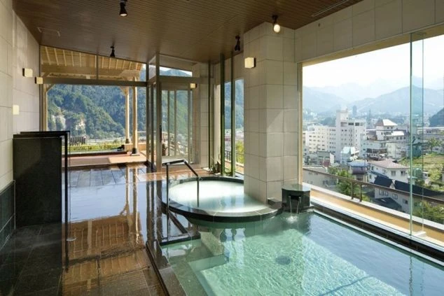  山を望む大きな窓がある、屋内の温水プール。