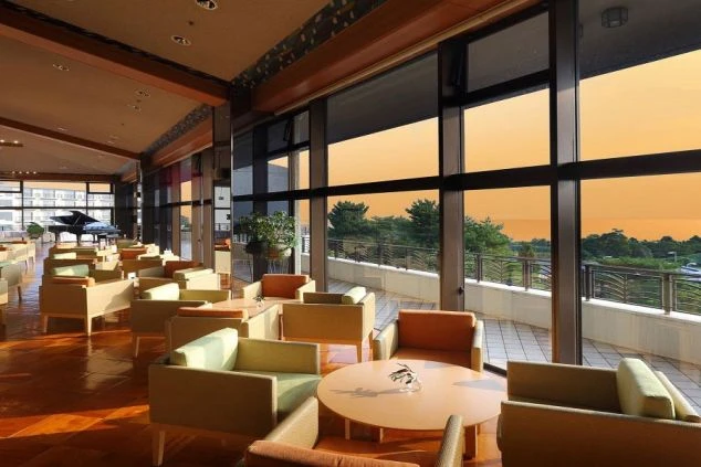 リゾートバイトの仕事風景を表現するイメージ画像。窓の外に夕焼けが見える、ホテルの広々としたラウンジ。