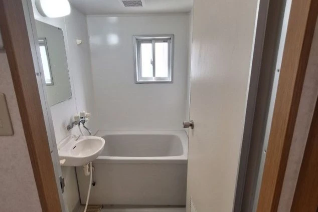 ユニットバスタイプの浴室の画像。浴槽、シャワー、洗面台が一体となったタイプで、リゾートバイトの個室寮に完備されている。一日の疲れを癒やせる清潔感のある空間が伝わる画像。